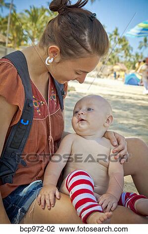 Stock Image - Seated mother holding baby. Fotosearch