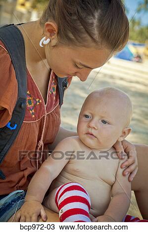 Seated mother holding baby View Large Photo Image Stock Image - Seated mother holding baby. Fotosearch