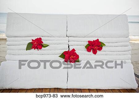 Stack of folded towels with flowers View Large Photo Image Stock Image - Stack of folded towels with flowers. Fotosearch