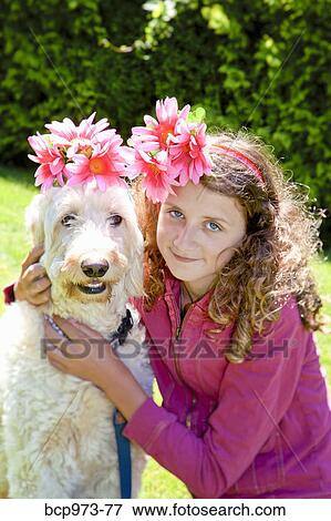 Stock Photo - Teen girl and white dog wearing flowers. Fotosearch