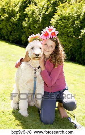 Stock Photo - Teen girl and white dog wearing flowers. Fotosearch