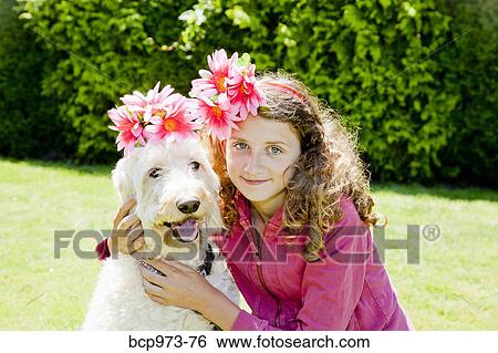 Stock Photograph - Teen girl and white dog wearing flowers. Fotosearch