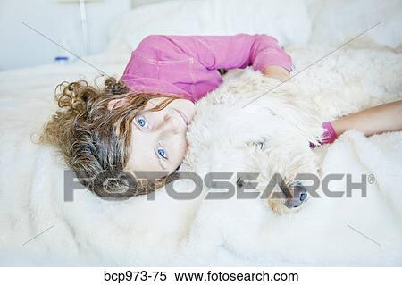 Teen girl cuddling dog on bed View Large Photo Image Stock Photography - Teen girl cuddling dog on bed. Fotosearch