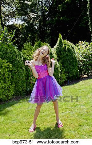 Teen girl in party dress listening to music outdoors View Large Photo Image Stock Image - Teen girl in party dress listening to music outdoors. Fotosearch