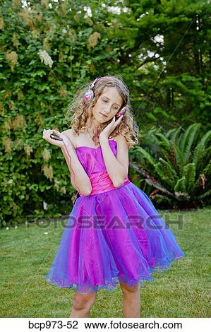 Teen girl in party dress listening to music outdoors View Large Photo Image Stock Image - Teen girl in party dress listening to music outdoors. Fotosearch