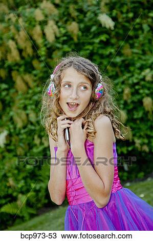Teen girl in party dress listening to music outdoors View Large Photo Image Stock Image - Teen girl in party dress listening to music outdoors. Fotosearch