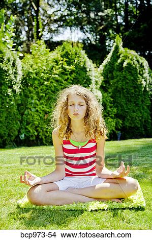 Picture - Teen girl meditating outdoors. Fotosearch