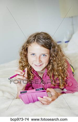 Teen girl on bed with tablet View Large Photo Image Picture - Teen girl on bed with tablet. Fotosearch