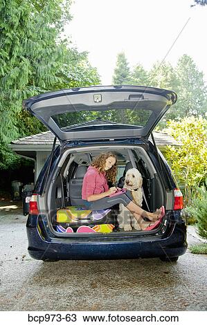 Teen girl with luggage and dog in car View Large Photo Image Stock Image - Teen girl with luggage and dog in car. Fotosearch