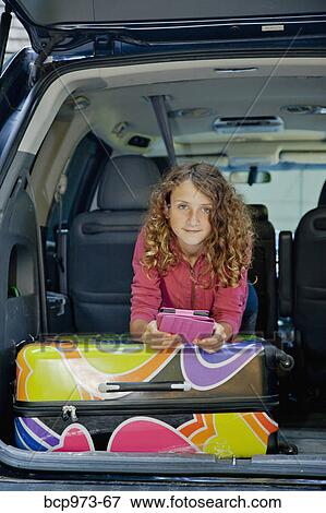 Stock Photo - Teen girl with luggage in car. Fotosearch