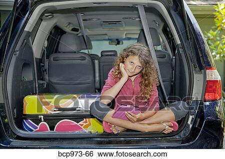 Stock Photograph - Teen girl with luggage in car. Fotosearch