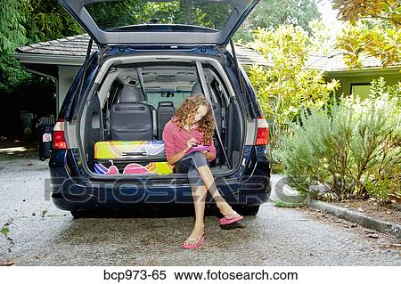 Stock Photography - Teen girl with luggage in car. Fotosearch