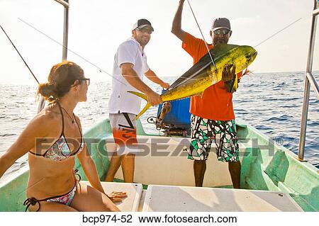 Stock Image - Three people on charter fishing boat. Fotosearch