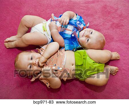 Twin babies on pink rug View Large Photo Image Stock Image - Twin babies on pink rug. Fotosearch