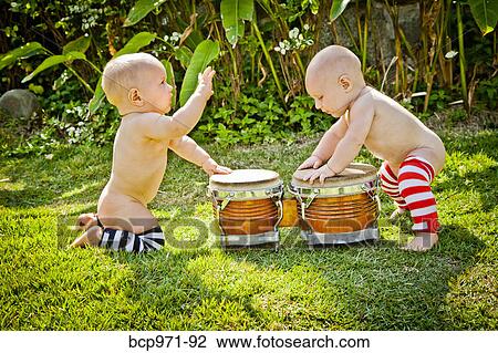 Twin babies playing drums outdoors View Large Photo Image Stock Image - Twin babies playing drums outdoors. Fotosearch