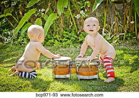 Twin babies playing drums outdoors View Large Photo Image Stock Image - Twin babies playing drums outdoors. Fotosearch