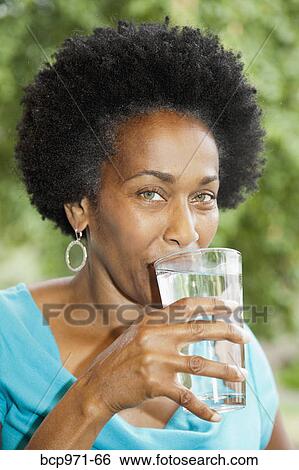 Woman drinking glass of water View Large Photo Image Stock Photograph - Woman drinking glass of water. Fotosearch