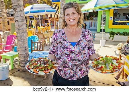 Woman holding plates of mexican food View Large Photo Image Stock Photo - Woman holding plates of mexican food. Fotosearch