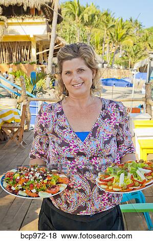 Stock Photo - Woman holding plates of mexican food. Fotosearch