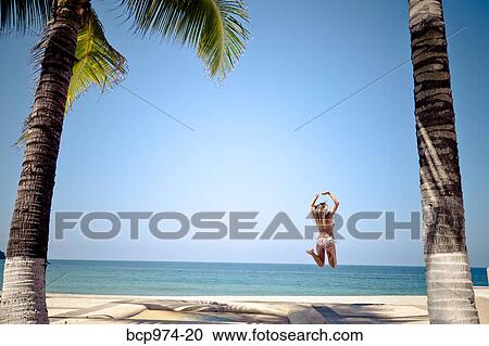 Woman in bikini jumping on beach View Large Photo Image Stock Image - Woman in bikini jumping on beach. Fotosearch