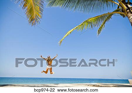 Woman in bikini jumping on beach View Large Photo Image Stock Image - Woman in bikini jumping on beach. Fotosearch