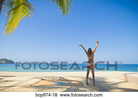 Woman in bikini jumping on beach View Large Photo Image Stock Photo - Woman in bikini jumping on beach. Fotosearch