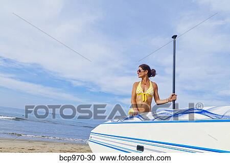 Woman on beach with paddle board View Large Photo Image Stock Image - Woman on beach with paddle board. Fotosearch