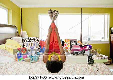 Woman on bed with shopping bags and shoes View Large Photo Image Stock Photography - Woman on bed with shopping bags and shoes. Fotosearch