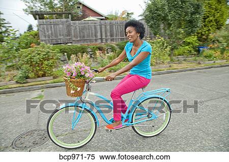 Woman riding retro bicycle with flower basket View Large Photo Image Stock Photography - Woman riding retro bicycle with flower basket. Fotosearch