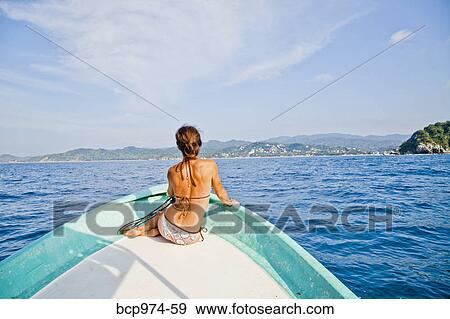 Stock Photo - Woman sitting in bow of boat. Fotosearch