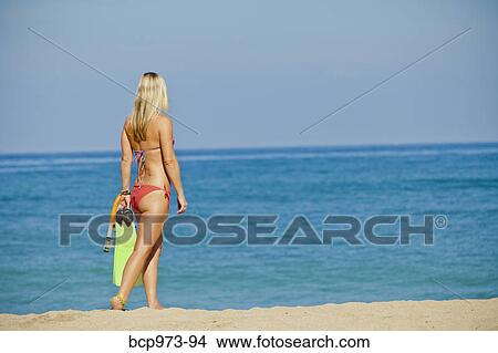 Woman walking on beach carrying swim fins View Large Photo Image Picture - Woman walking on beach carrying swim fins. Fotosearch