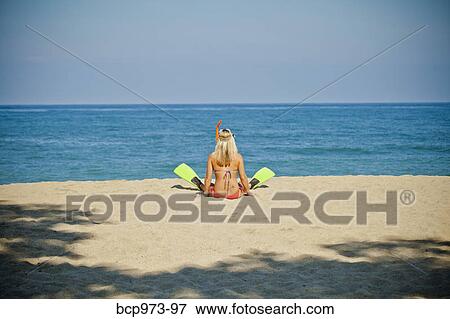 Woman wearing swim fins sitting on beach View Large Photo Image Stock Photo - Woman wearing swim fins sitting on beach. Fotosearch