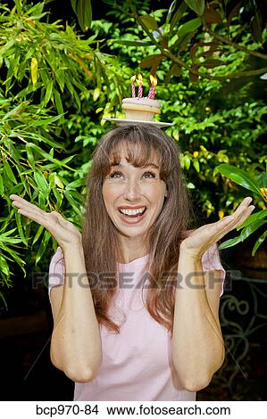 Woman with birthday cupcake on head View Large Photo Image Picture - Woman with birthday cupcake on head. Fotosearch