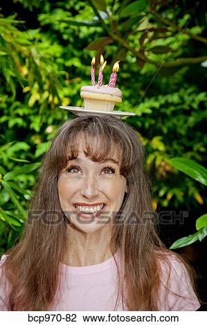 Woman with birthday cupcake on head View Large Photo Image Stock Image - Woman with birthday cupcake on head. Fotosearch