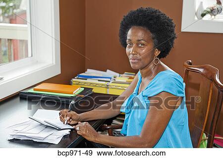 Woman working at home office View Large Photo Image Stock Photo - Woman working at home office. Fotosearch