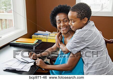 Woman working at home office with son View Large Photo Image Stock Photograph - Woman working at home office with son. Fotosearch