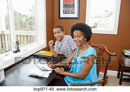 Woman working at home office with son View Large Photo Image Stock Photography - Woman working at home office with son. Fotosearch