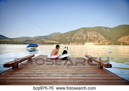 Young boy and dog wearing float rings on dock View Large Photo Image Stock Image - Young boy and dog wearing float rings on dock. Fotosearch