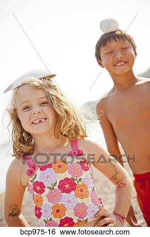 Young boy and girl balancing shells on their heads View Large Photo Image Stock Photograph - Young boy and girl balancing shells on their heads. Fotosearch