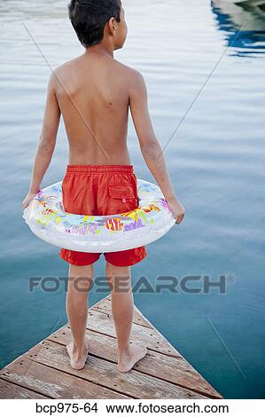 Picture - Young boy wearing float ring on dock. Fotosearch