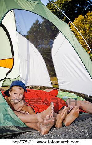 Young boy's face and pairs of feet poking out of tent View Large Photo Image Stock Image - Young boy's face and pairs of feet poking out of tent. Fotosearch