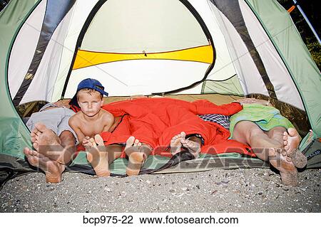 Young boy's face and pairs of feet poking out of tent View Large Photo Image Stock Image - Young boy's face and pairs of feet poking out of tent. Fotosearch