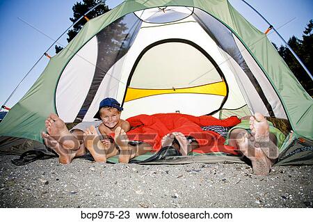 Young boy's face and pairs of feet poking out of tent View Large Photo Image Stock Image - Young boy's face and pairs of feet poking out of tent. Fotosearch