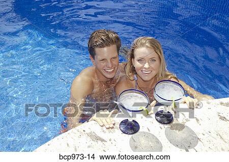 Young couple with cocktails in pool View Large Photo Image Picture - Young couple with cocktails in pool. Fotosearch