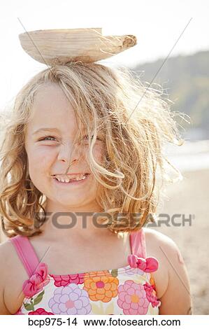Young girl balancing large seashell on her head View Large Photo Image Picture - Young girl balancing large seashell on her head. Fotosearch