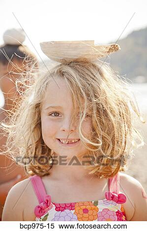Young girl balancing large seashell on her head View Large Photo Image Stock Photography - Young girl balancing large seashell on her head. Fotosearch
