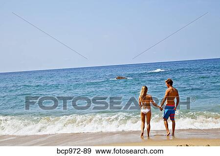 Young man and woman looking at surf View Large Photo Image Stock Photo - Young man and woman looking at surf. Fotosearch