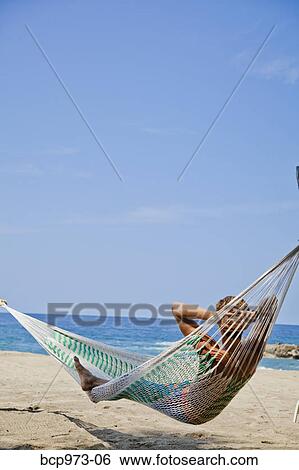 Young man in hammock on beach View Large Photo Image Stock Photograph - Young man in hammock on beach. Fotosearch