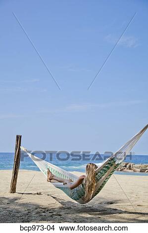 Picture - Young woman in hammock on beach. Fotosearch