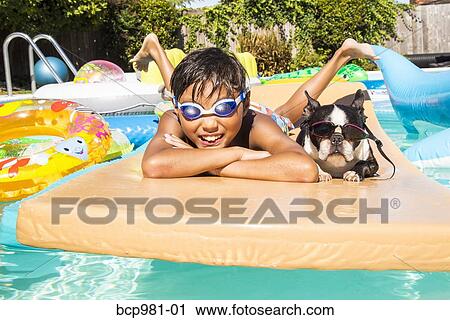 Boy and his Boston Terrier wearing matching goggles float on a toy in a pool View Large Photo Image Stock Image - Boy and his Boston Terrier wearing matching goggles float on a toy in a pool. Fotosearch
